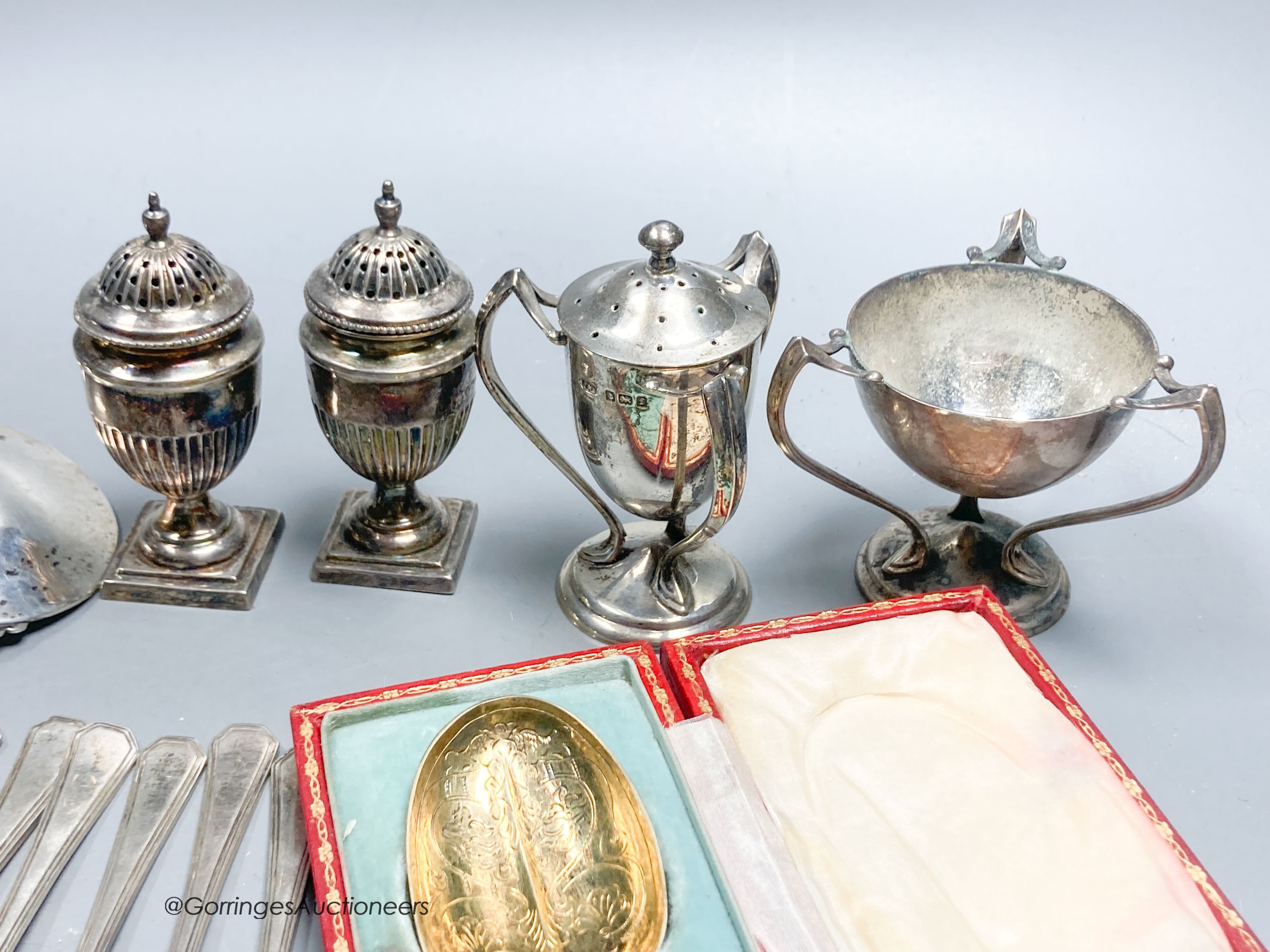 Sundry small silver including cased spoon, two mounted inkwells, two small trophy cups, condiments, cake forks etc.